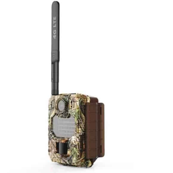 Uovision Compact LTE 4G 20MP riistakamera maastokuosilla, oikealta sivulta kuvattuna.